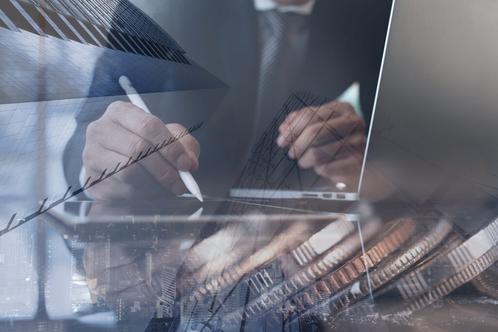 Financial investment background concept. Double exposure of  businessman, accountant, finance analyst working on laptop and digital tablet in office, bank buildings and  coins